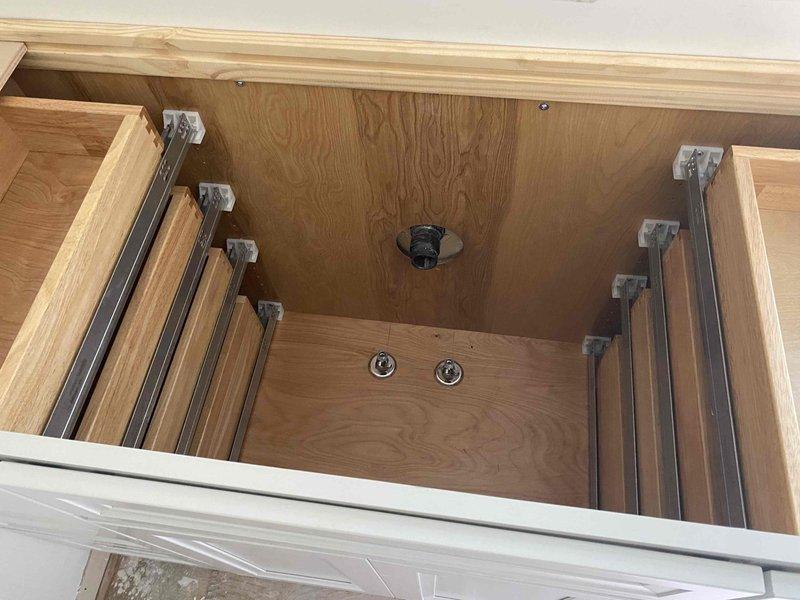 Returned to complete final plumbing installation on active construction project. Completed rough-in connections including copper supply line routing to bathroom vanity location, verified proper drainage assembly installation in vanity cabinet drawer base, and ensured all plumbing components were level and properly aligned with stair construction work in progress.