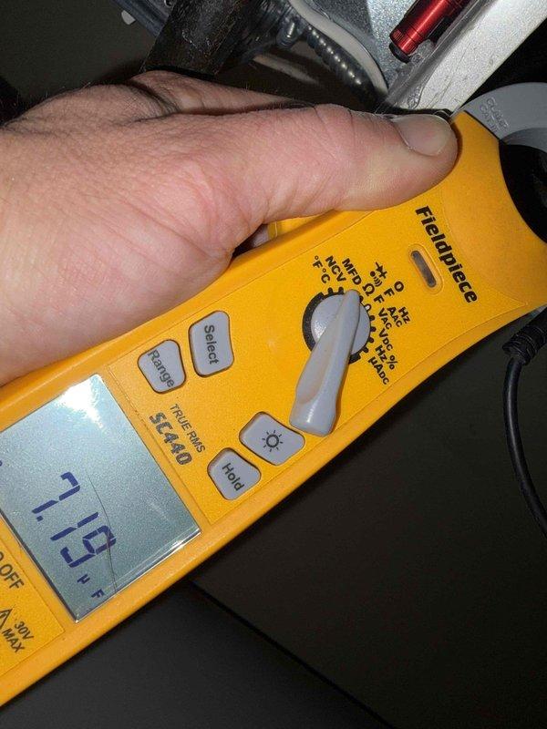 Completed cooling maintenance on air handler unit as part of club membership service. Performed diagnostic testing using digital multimeter, recording voltage reading of 335V and temperature measurement of 119°F to verify system operation and component performance. Inspected HVAC equipment including ventilation components and documented conditions through photos for service records.