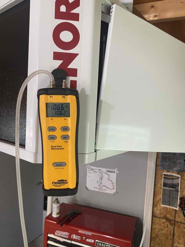 Returned to complete propane gas regulator installation following material arrival. Performed diagnostic testing using digital manometer to verify gas pressure readings at 1865 on both P1 and P2 channels, ensuring proper system operation. Accessed HVAC equipment internal components to complete electrical connections and wiring integration for the new regulator. Verified all wire terminations and tested system functionality to confirm safe operation of the propane gas supply system.