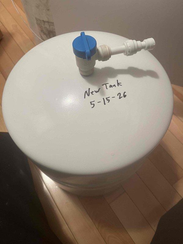 Completed water treatment system maintenance by servicing MRO filters and inspecting associated equipment. Installed new water treatment tank with control valve assembly and blue-handled bypass component, marked with installation date for future reference. Verified proper operation of under-sink plumbing connections, including supply lines, shut-off valves, and PVC drain system to ensure full system integration and functionality.