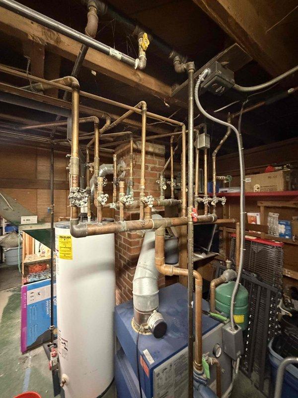 Responded to no heat complaint affecting upstairs zones on aging boiler system. Inspected multi-zone hydronic heating system including boiler, circulator pumps, zone valves, and distribution piping throughout basement utility area. Identified malfunctioning zone valve preventing hot water circulation to upper floor heating loop. Verified boiler operation and primary loop functionality, confirmed proper water temperature and pressure levels. Cycled zone valves and tested electrical connections to isolate failed component affecting upstairs heat delivery.