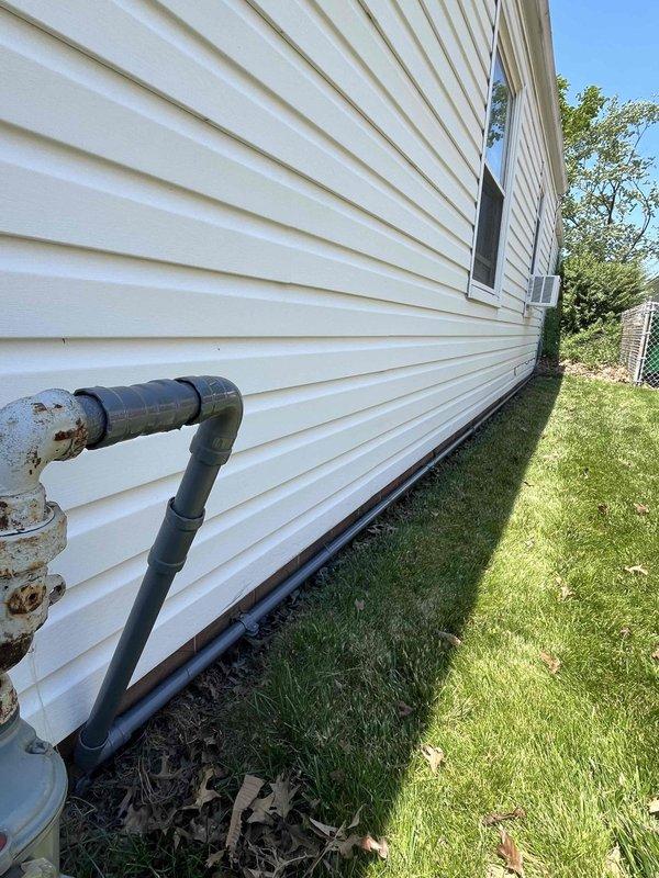 Completed follow-up visit to sand and paint gas line that was unable to be finished during previous fall service call. Prepared surface of exposed PVC gas piping running along building foundation, including vertical and horizontal sections with elbow fittings. Applied appropriate coating to protect piping system from weathering and UV exposure. Cleared debris and leaves from work area around foundation to ensure proper access and finish quality.
