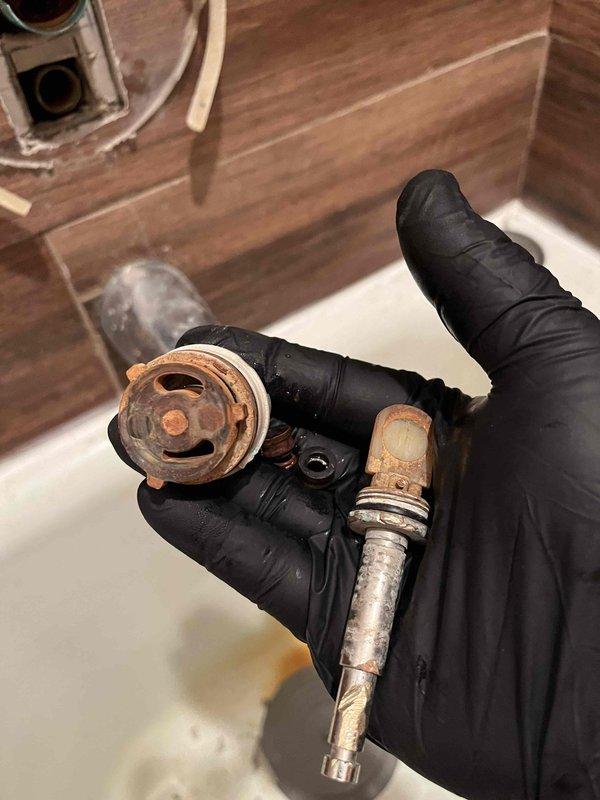 Returned to property to address shower cartridge replacement that was previously sold. Upon inspection, removed severely corroded Delta valve assembly from shower, which exhibited extensive rust buildup, deteriorated chrome finish, and compromised threaded connections. The corrosion had caused visible staining in the bathtub area. Accessed plumbing through existing floor access point with foam insulation ring and verified cartridge compatibility. Documented existing conditions and confirmed Delta replacement parts availability for installation upon verification of exact model specifications.