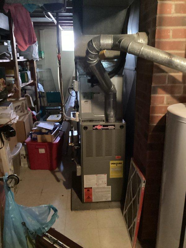 Conducted on-site assessment of 23-year-old residential HVAC system for replacement estimate. Inspected existing furnace unit located in basement utility area and evaluated ductwork configuration, including metallic supply plenum and trunk connections. Documented current equipment specifications, manufacturer information, and overall system condition. Evaluated thermostat functionality and confirmed filter service reminder active on digital display. Photographed existing equipment installation, ductwork layout, and control system to support replacement proposal for aged heating and cooling system at end of serviceable life.