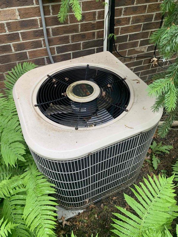 Responded to no cooling complaint with unit blowing warm air. Upon arrival, performed diagnostic assessment of outdoor condenser unit and measured electrical readings using digital multimeter, which indicated 6063 on display during testing. Inspected condenser unit exterior, noting accumulated debris and dirt on top panel and surrounding area, with vegetation growth encroaching on unit perimeter. Conducted systematic troubleshooting to identify root cause of warm air issue and verified thermostat display was functioning properly at time of service.