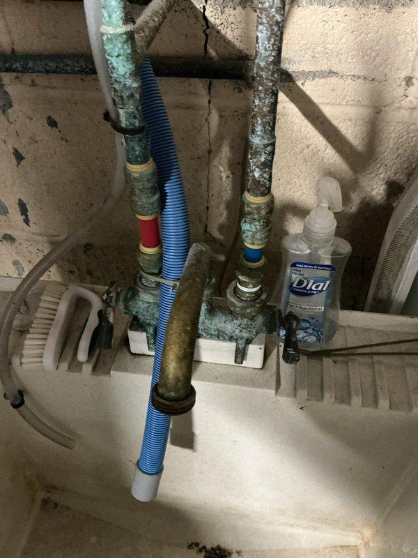 Completed plumbing maintenance club visit to investigate reported noise during water heating operation. Inspected water heater system and confirmed standard tank-type unit, not tankless. Examined utility area plumbing infrastructure including corroded copper supply lines with significant verdigris patina buildup indicating age and moisture exposure. Assessed bathroom shower fixtures and tub-spout assembly for proper operation and potential noise sources related to water heating cycle.