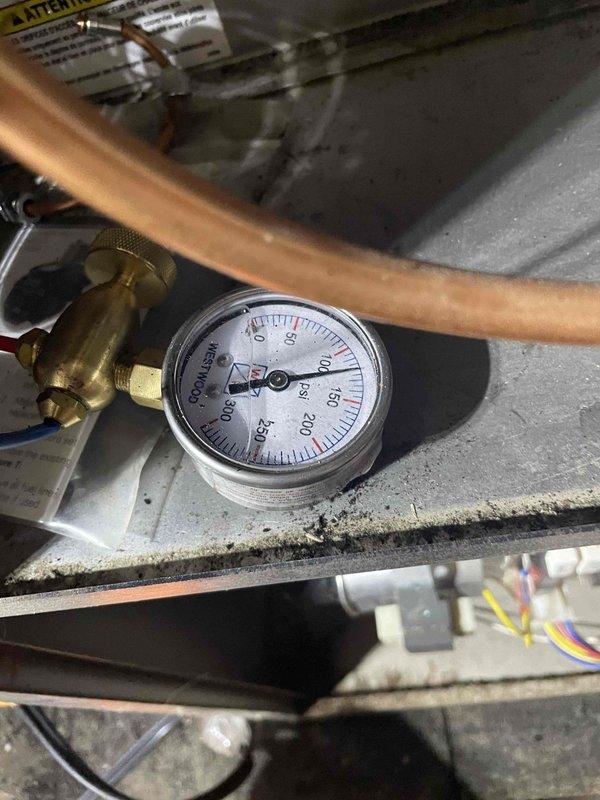 Returned to address ongoing soot discharge from furnace system. Performed diagnostic pressure testing using manifold gauges on refrigeration lines to assess system performance and identify potential combustion issues. Documented equipment conditions and pressure readings with photographic evidence for service records and warranty claim processing related to equipment previously installed.