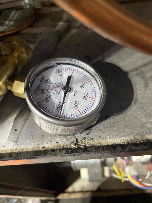 Returned to address ongoing soot discharge from furnace system. Performed diagnostic pressure testing using manifold gauges on refrigeration lines to assess system performance and identify potential combustion issues. Documented equipment conditions and pressure readings with photographic evidence for service records and warranty claim processing related to equipment previously installed.