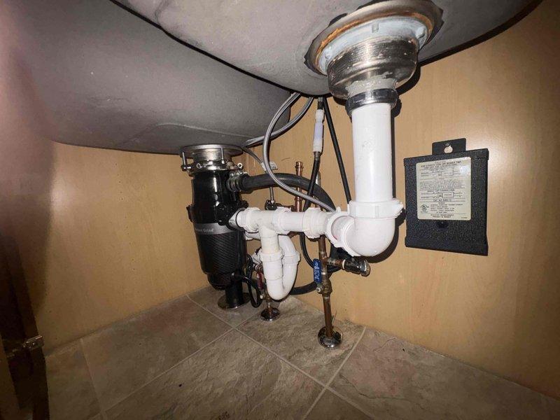 Responded to clogged garbage disposal and kitchen sink. Upon inspection, found blockage in the disposal unit and drain line. Cleared obstruction from disposal grinding chamber and flushed P-trap assembly to restore proper drainage. Tested disposal operation and verified water flow through sink drain with no leaks detected at connections.