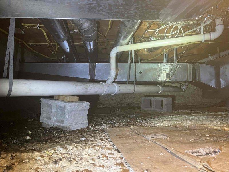 Completed comprehensive crawl space repipe installation featuring new white PVC drainage and plumbing system with properly secured pipe runs, hangers, and multiple connection points throughout the under-floor area. All piping was professionally routed alongside existing HVAC ductwork and electrical systems, with proper support strapping and clearances maintained per code requirements.