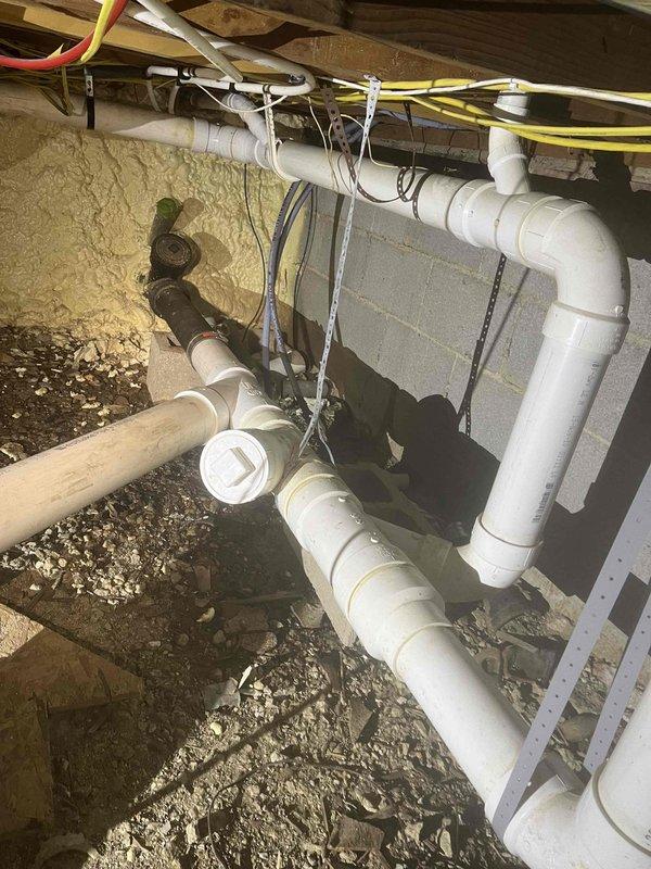 Completed comprehensive crawl space repipe installation featuring new white PVC drainage and plumbing system with properly secured pipe runs, hangers, and multiple connection points throughout the under-floor area. All piping was professionally routed alongside existing HVAC ductwork and electrical systems, with proper support strapping and clearances maintained per code requirements.