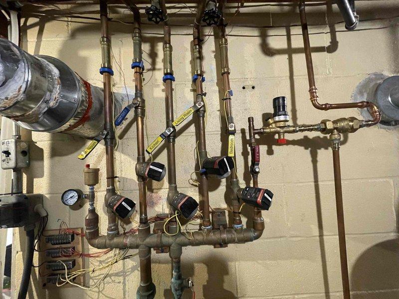 Completed comprehensive boiler maintenance inspection including visual assessment of hydronic piping manifold system, zone valves, and circulation components. Verified proper pressure and temperature readings on system gauges, inspected copper distribution lines and fittings for leaks or corrosion, and documented equipment condition with photographic records for member files.