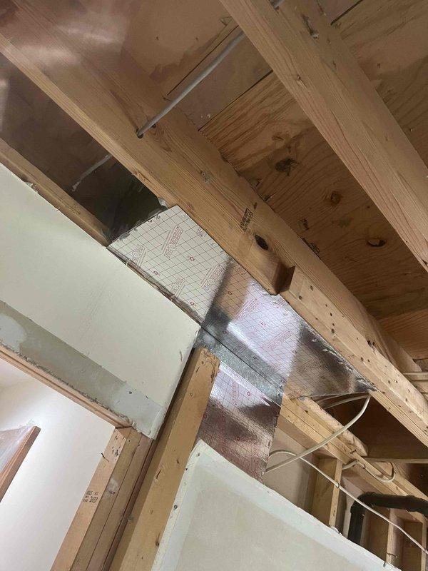 Installed new return air ductwork routing from the main HVAC system to the back door area of the garage. Work included framing modifications, proper insulation installation with foil-faced and rigid foam board materials, and securing all ductwork components with appropriate metal brackets and hangers to ensure efficient airflow and system performance.
