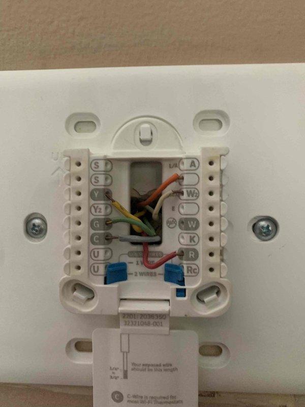 Responded to no cooling complaint on heat pump system following recent heatwave. Upon arrival, verified outdoor unit was running but not producing cold air, with thermostat set below room temperature and system showing "idle" status. Inspected American Standard thermostat wiring at wall plate and confirmed all terminal connections were secure, including Y (compressor), G (fan), R (power), C (common), and heat pump-specific wiring. Thermostat display showed 68°F actual temperature with proper power and communication to system. Further diagnostics revealed low refrigerant charge in heat pump system, likely due to small leak that developed during extended operation in extreme heat conditions. Recharged system to manufacturer specifications and verified proper cooling operation resumed with appropriate temperature differential across coil. Advised monitoring system performance and recommended leak detection service if cooling issues return.