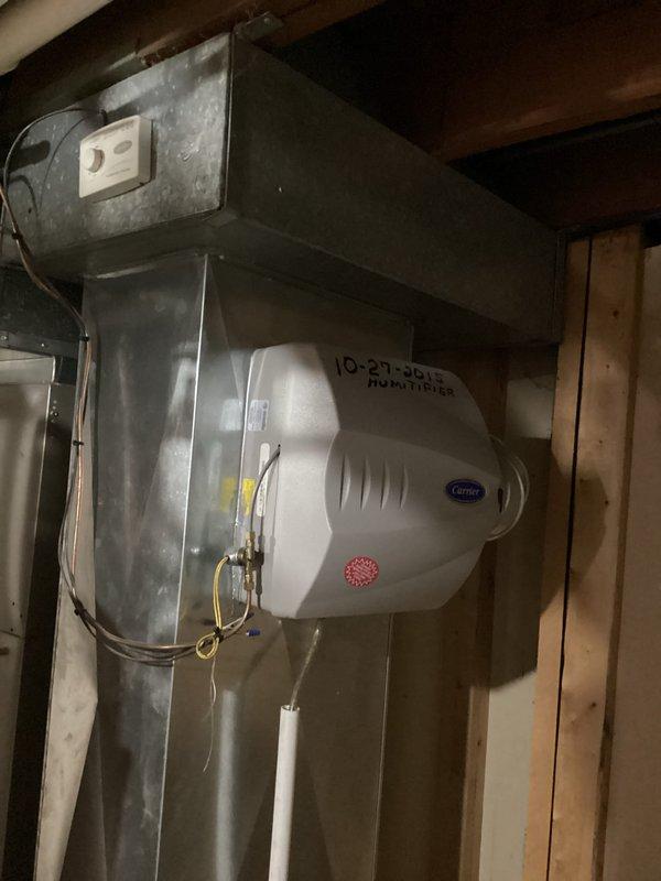 Conducted on-site evaluation of existing central air conditioning system to provide replacement estimate. Inspected current HVAC installation in basement utility area, including existing ductwork, Carrier-branded humidifier unit dated from 2015, and associated electrical components. Documented equipment condition and configuration through photographs to support comprehensive replacement quote for new central air system.