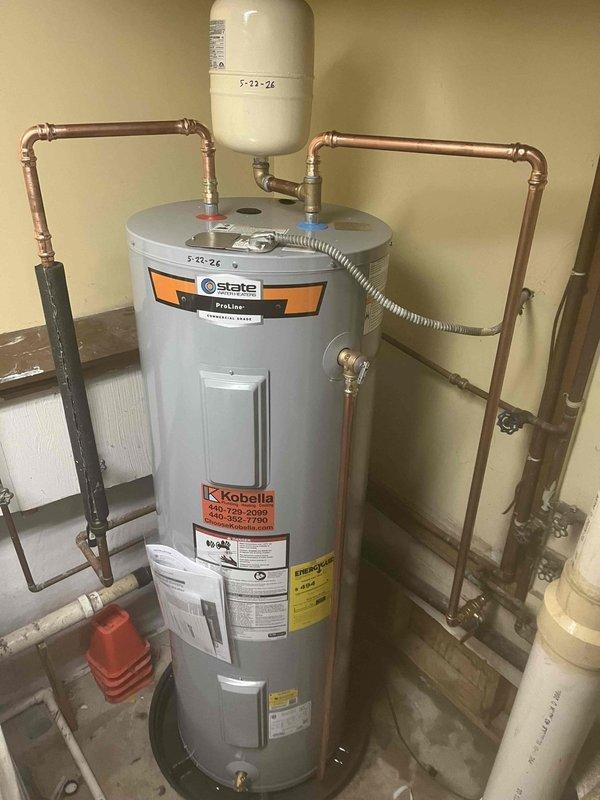 Completed residential tanked water heater installation with full copper piping system integration. Installed State brand water heater unit with proper expansion tank mounting, flexible connector hose, and comprehensive shut-off valve configuration throughout the copper pipe network. Exercised extra care during installation to protect newly refinished flooring in the work area, ensuring clean and professional completion of all plumbing connections and safety components.