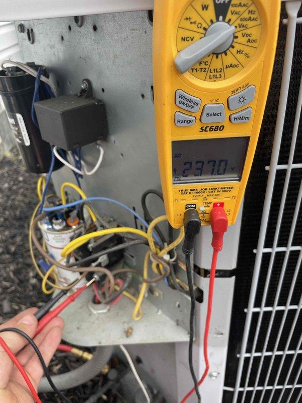 Completed scheduled maintenance on 11-year-old Carrier air conditioning system per maintenance contract. Performed comprehensive AC tune-up including electrical diagnostics using digital multimeter to verify voltage readings at 237V on control circuit components. Inspected and tested capacitor, contactor relay, and associated wiring connections within control panel. Evaluated outdoor condenser unit condition, verified proper operation of condenser coil and fan assembly, and confirmed unit is mounted securely on pad with adequate clearance. All components operating within normal parameters with no immediate service needs identified.