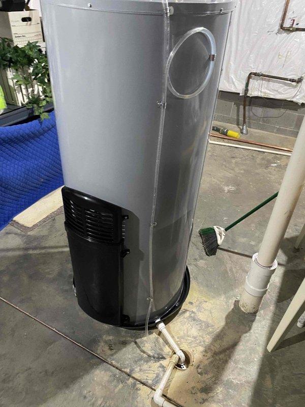 Completed replacement of 75-gallon water heater in basement mechanical room. Removed existing unit and installed new water heater with proper connections to existing white PVC piping system. Installed pressure relief valve with Watts gauge assembly, including brass backflow preventer and threaded fittings to monitor system pressure. Connected hot and cold water supply lines with shutoff valves featuring color-coded indicators for easy identification. Verified all connections for proper seal and tested system pressure within acceptable operating range. Job required approximately four hours to complete with additional technician assistance due to unit size and weight. Protected work area with plastic sheeting and moving blankets during installation process.