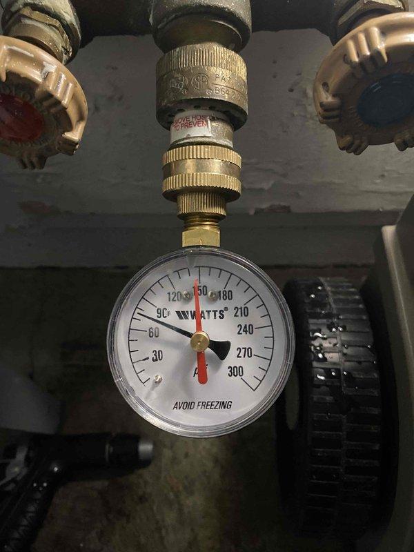 Completed replacement of 75-gallon water heater in basement mechanical room. Removed existing unit and installed new water heater with proper connections to existing white PVC piping system. Installed pressure relief valve with Watts gauge assembly, including brass backflow preventer and threaded fittings to monitor system pressure. Connected hot and cold water supply lines with shutoff valves featuring color-coded indicators for easy identification. Verified all connections for proper seal and tested system pressure within acceptable operating range. Job required approximately four hours to complete with additional technician assistance due to unit size and weight. Protected work area with plastic sheeting and moving blankets during installation process.