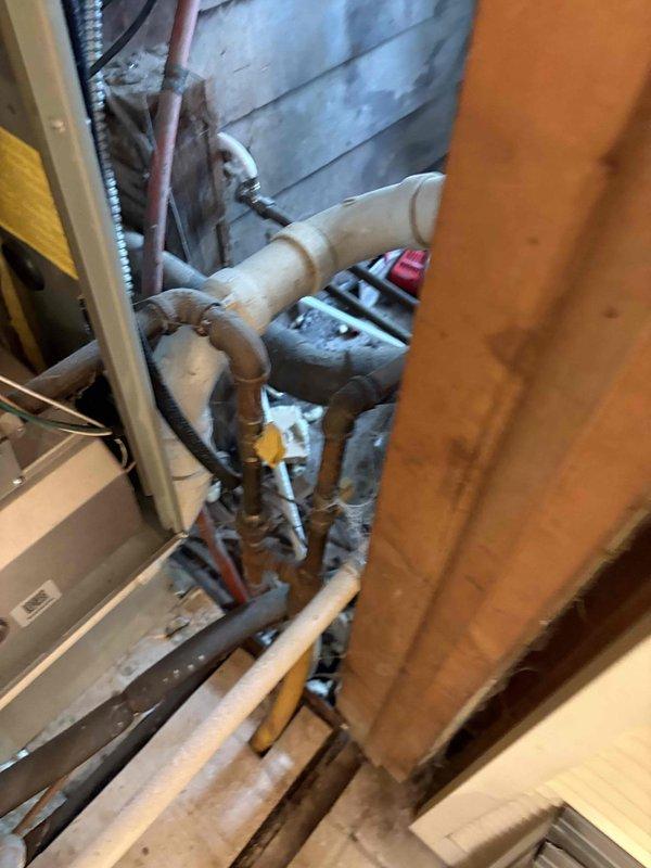 Responded to service call for air conditioning unit making strange noises and not operating. Upon inspection, determined system age and condition warranted full replacement rather than repair. Provided comprehensive estimate for complete HVAC system replacement, documenting existing equipment configuration including control board wiring, electrical connections, and mechanical components in confined crawlspace installation. Photographed current system setup showing multi-wire terminal connections, capacitor assembly, and existing infrastructure including PVC drainage, copper refrigerant lines, and flexible conduit to assist with replacement planning and equipment specifications.