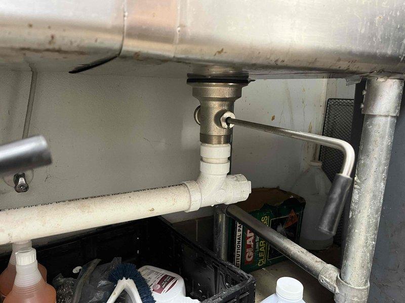 Responded to clogged drain call at hand washing station. Upon inspection, found blockage in drain assembly beneath sink. Cleared obstruction from P-trap and drain line, restoring proper water flow and drainage. Verified all connections were secure and tested system to ensure complete functionality.