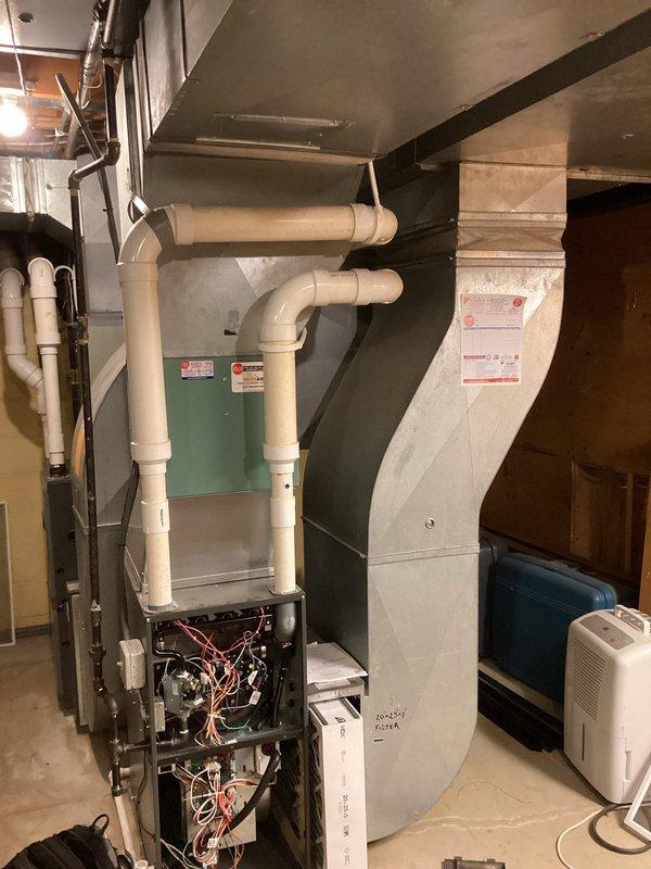 Completed HVAC estimate for replacement of dual-unit residential system including outdoor AC condenser units and indoor furnace equipment. The existing upstairs unit was found to have no refrigerant, and both aging systems required replacement evaluation. Documented current equipment conditions including weathered outdoor condensers positioned on concrete pads and basement furnace with exposed internal components for comprehensive replacement proposal.