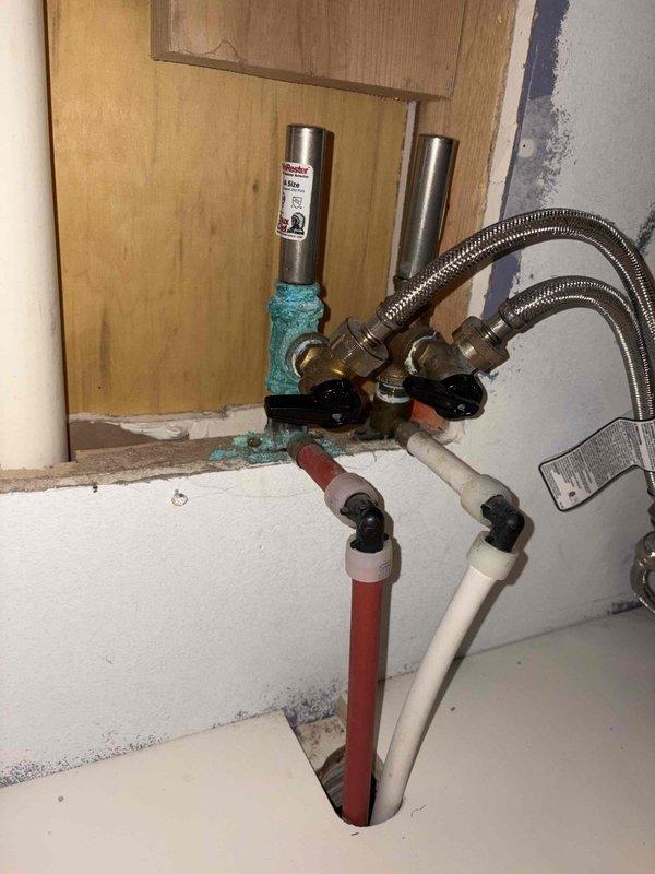 Responded to a hot water supply line leak at washing machine location. Upon inspection, identified active leak at connection point between hot water shut-off valve and braided flex supply hose serving the washing machine. Visible corrosion and mineral deposits were present on the affected valve and surrounding fittings, indicating long-term moisture exposure. Shut off water supply at fixture valves and removed compromised braided flex hose. Replaced defective hot water supply line with new stainless steel braided flexible connector, ensuring proper seal at both valve and appliance connections. Verified all connections were secure and leak-free. Restored water supply and tested system under full pressure to confirm repair integrity. Left work area clean with all connections functioning properly.