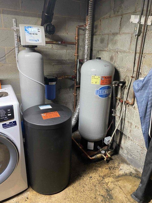 Responded to no water complaint at residential property with well water system. Upon arrival, conducted systematic diagnostic of water supply components including well pump, pressure tank, and distribution system. Inspection revealed Flexlite pressure tank with compromised air charge, preventing proper pressure cycling and water delivery to fixtures throughout home. 

Tested pressure switch operation and verified electrical supply to well pump was functioning correctly. Measured tank pressure at bladder valve and found insufficient air pressure to maintain proper water-to-air ratio within pressure vessel. Recharged pressure tank to manufacturer specifications using air compressor, adjusting to appropriate PSI for system operating range. Cycled system multiple times to verify proper cut-in and cut-out pressure points at pressure switch.

Inspected associated plumbing components including water softener system, pre-filtration equipment, and copper distribution lines for any secondary iss
