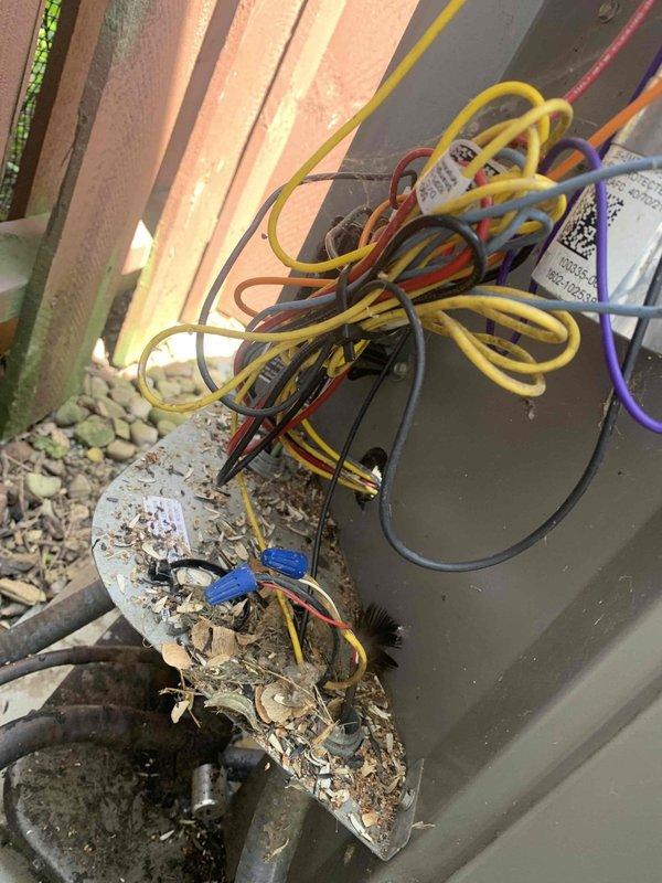 Responded to service call for air conditioning system not adequately cooling the property. Upon arrival, performed diagnostic inspection of the outdoor condensing unit and electrical connections. Observed exposed electrical wiring at the unit with multiple conductors entering through wall penetration, including proper color-coded wires routed into the equipment compartment. Inspected condenser coil, refrigerant lines, and electrical components for proper operation. Unit appeared to be functioning within normal parameters during inspection. Verified all electrical connections were secure and properly terminated. Recommended monitoring system performance and advised customer to contact for follow-up if cooling issues persist.