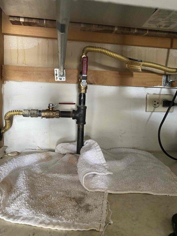 Installed half-inch gas shut-off valves for kitchen appliances as a return service call to complete previously sold repair. Replaced gas valves for both stove and oven connections, utilizing black iron pipe with brass fittings and flexible corrugated brass supply lines to ensure proper gas flow and safety compliance.
