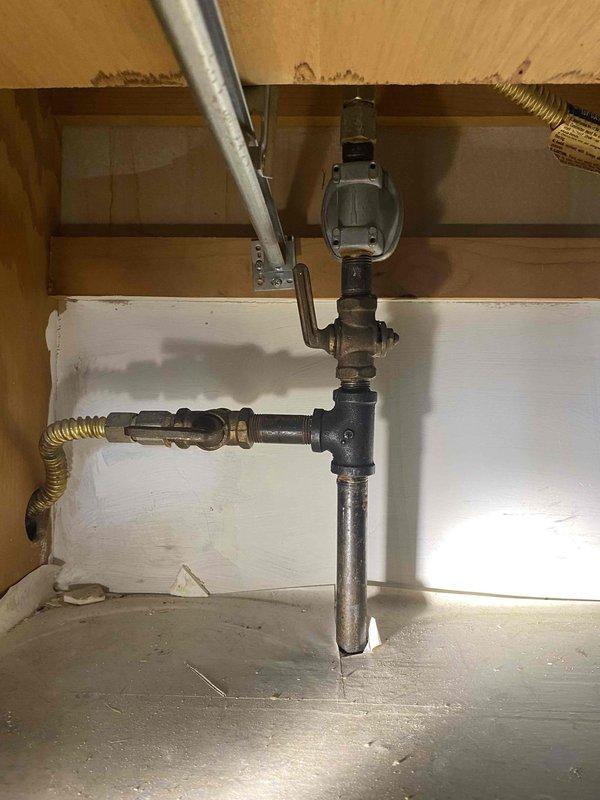 Installed half-inch gas shut-off valves for kitchen appliances as a return service call to complete previously sold repair. Replaced gas valves for both stove and oven connections, utilizing black iron pipe with brass fittings and flexible corrugated brass supply lines to ensure proper gas flow and safety compliance.