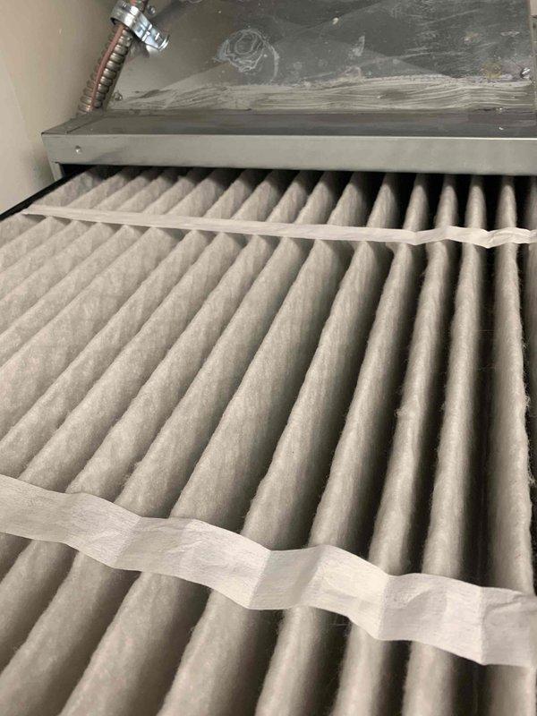 Responded to service call for loud noise from furnace when air conditioning system operates. Performed system inspection and AC tune-up on air handler unit. Inspected and documented condition of air filtration system, noting dust accumulation on pleated filters. Verified electrical parameters using digital multimeter, measuring 243.2 volts AC supply to unit with proper voltage readings. Checked amperage draw showing 0.00A at time of measurement. Completed preventive maintenance procedures on air handler equipment and documented system conditions with photographs for service records.