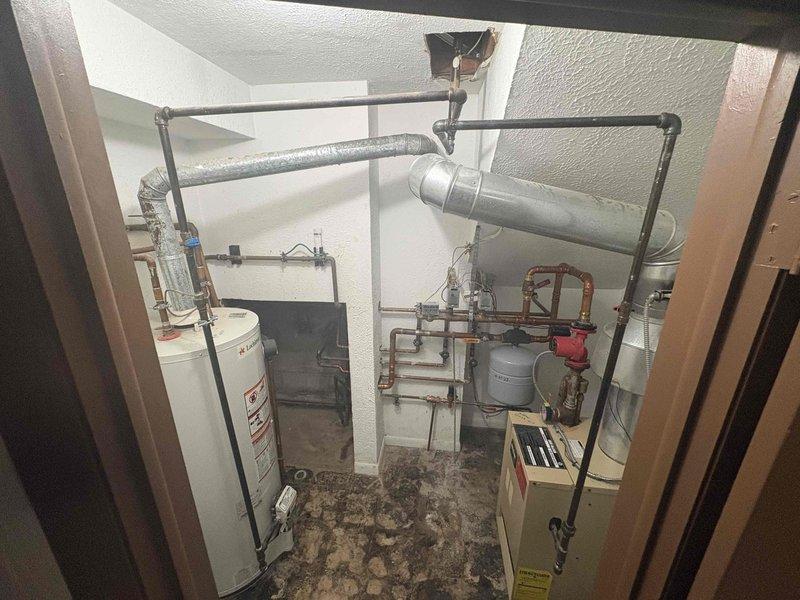 Responded to gas leak identified by utility company in vicinity of boiler piping. Performed visual inspection of black iron gas piping system, noting aged infrastructure with visible corrosion and surface deterioration at T-junction fittings and threaded connections. Documented condition of gas lines serving water heater and HVAC equipment in mechanical room. Recommended further pressure testing and leak detection procedures to isolate exact location of internal gas leak before system can be safely restored to operation.