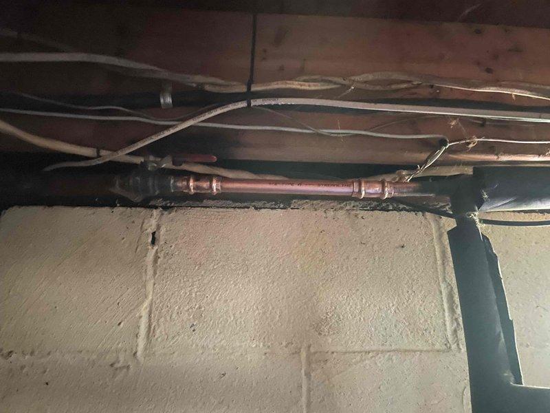 Replaced defective outdoor faucet and associated interior copper supply piping in basement. Removed existing corroded valve assembly and deteriorated pipe section, installed new frost-proof sillcock with updated shutoff valve for seasonal winterization, and secured new copper supply line to floor joists with proper hangers to ensure code-compliant installation and prevent future leaks.