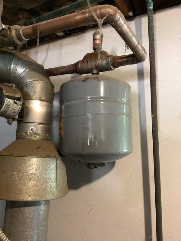 Conducted estimate for replacement of two thermostats and expansion valve on a 1993 gas-fired hot water boiler system. Inspected 33-year-old boiler installation and documented existing expansion tank with visible age-related wear, copper piping configuration with brass fittings, and associated mechanical components in utility area. Provided replacement recommendations for aging control components to maintain system reliability.