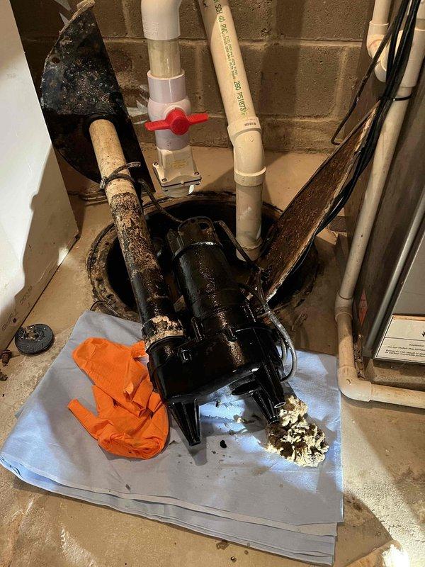 Responded to service call for non-operational waste/ejector pump system that had experienced a previous failure earlier in the month. Upon arrival, inspected the sump pit installation and associated discharge piping. Identified heavily corroded discharge pipes with significant oxidation and surface degradation affecting pump performance. Removed failed pump unit from pit and assessed system components including PVC discharge lines, ball valve assembly, and electrical connections. Replaced deteriorated piping connections and reinstalled functional pump assembly on protective sheeting to prevent floor contact issues. Verified proper pump operation, tested ball valve functionality, and ensured adequate water discharge through the system. System restored to full operational status.