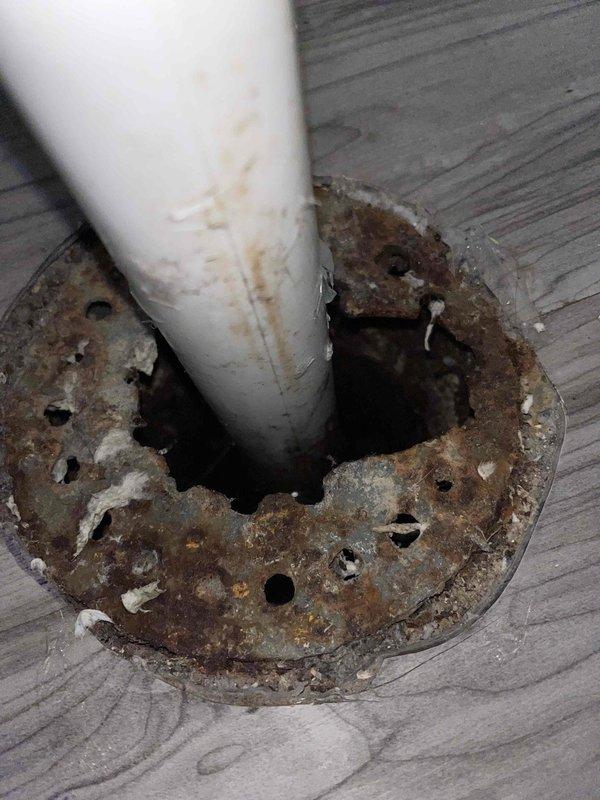Responded to backup issue in basement of 73-year-old residential property. Upon inspection, found severely corroded plumbing components including deteriorated metal flange at pipe penetration point and heavily corroded drain line coil/spring mechanism. Deployed powered drain auger to clear blockage in main basement drain line. Successfully removed obstruction and restored proper drainage flow. Documented existing corrosion on vintage plumbing infrastructure for homeowner's awareness regarding future maintenance needs.