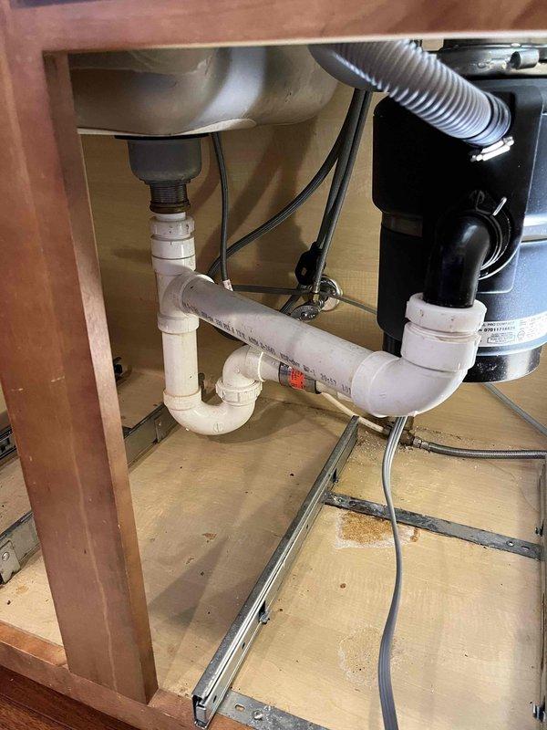 Responded to complaint of slow-draining kitchen sink. Upon inspection, verified reduced flow rate at kitchen drain. Cleared blockage from P-trap assembly beneath sink, removing accumulated food debris and grease buildup. Tested drainage system to confirm proper flow restoration. Verified garbage disposal unit and all plumbing connections for proper operation and absence of leaks.