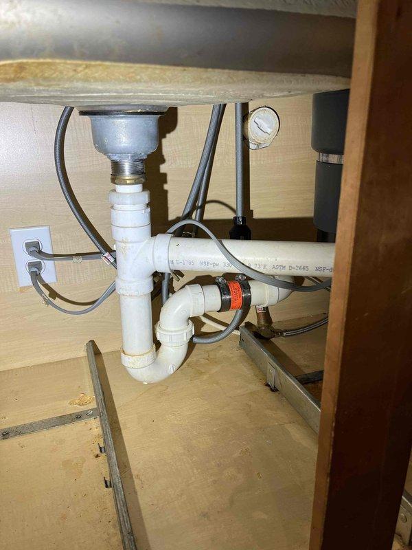Responded to complaint of slow-draining kitchen sink. Upon inspection, verified reduced flow rate at kitchen drain. Cleared blockage from P-trap assembly beneath sink, removing accumulated food debris and grease buildup. Tested drainage system to confirm proper flow restoration. Verified garbage disposal unit and all plumbing connections for proper operation and absence of leaks.