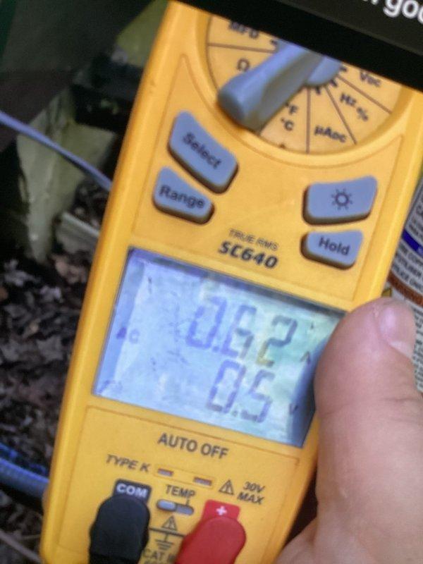 Performed cooling maintenance and system diagnostics on dual-zone HVAC system experiencing temperature imbalance between floors. Utilized digital multimeter to measure and verify electrical readings and system performance parameters, documenting findings with diagnostic measurements showing 0.62/0.5 readings and 0.18/0.0 readings across different test points. Inspected outdoor unit components and refrigerant lines to identify potential airflow restrictions or mechanical issues causing inadequate cooling distribution to lower level while upper level overheats.