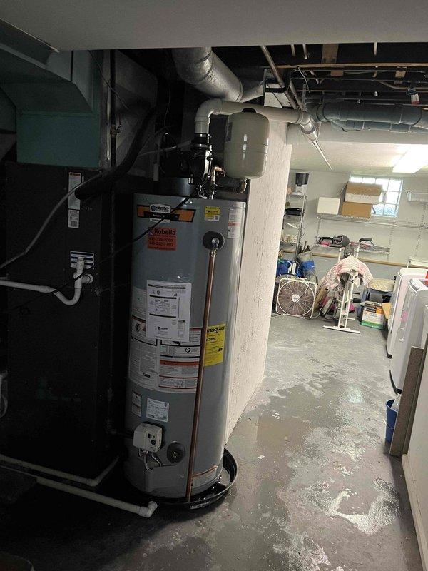 Completed installation of 50-gallon power vent water heater in basement utility area, including connection of black PVC venting system and all necessary water supply lines. Installed frost-free hose bib beneath exterior deck structure, mounting unit to wooden support post with copper supply line routed through floor joists. Both installations tested and verified operational with no leaks detected.