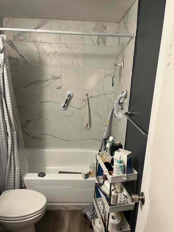 Responded to water leak complaint in kitchen area of 1970s condo unit. Investigated moisture appearing on floor under cabinets with no visible source near sink or dishwasher. Conducted thorough inspection of upstairs bathroom plumbing system, as homeowner reported correlation between leak occurrence and use of upstairs shower/bath. Examined tub-shower combination unit, shower fixtures, drain connections, and supply lines for signs of active leakage or deterioration. Inspected toilet base and wax ring seal area, noting previous seal replacement had been performed. Evaluated visible plumbing infrastructure in crawl space or basement area, checking for compromised drain lines, supply pipes, and potential shower pan leakage that could be migrating downward through floor structure. Assessed condition of aging galvanized or copper piping system consistent with building age. Documented findings with photographs of bathroom fixtures and accessible plumbing components. No active water flow was 