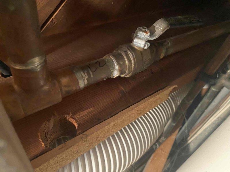 Responded to service call for leaking valve on boiler system. Upon inspection, identified compromised valve connection on copper piping with visible moisture and deterioration at joint. Documented condition with photos and video showing valve assembly beneath flooring area with evidence of active leak at connection point.