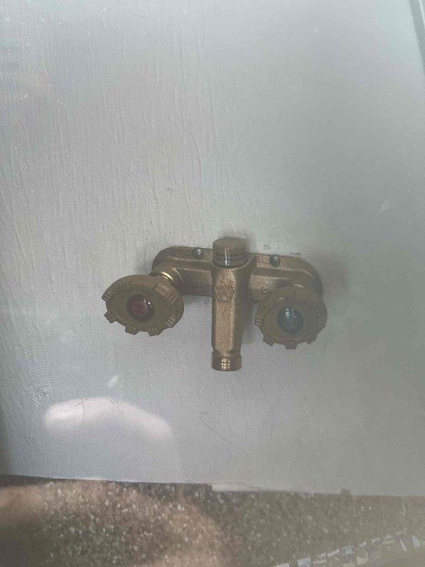 Upgraded outdoor spigot fixture to dual-handle configuration with both hot and cold water supply lines. Installed brass dual-handle valve assembly on exterior wall, connecting to existing plumbing infrastructure to provide temperature-controlled water access for outdoor use.