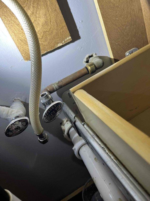 Responded to emergency call for leaking water shutoff valve in seventy-year-old residential property. Assessed existing plumbing configuration including aged copper piping, chrome shut-off valves, flexible braided supply lines, and PVC drainage components. Replaced faulty shutoff valve to eliminate active water leak and restore proper system operation, ensuring all connections were secure and tested for integrity before completing service.