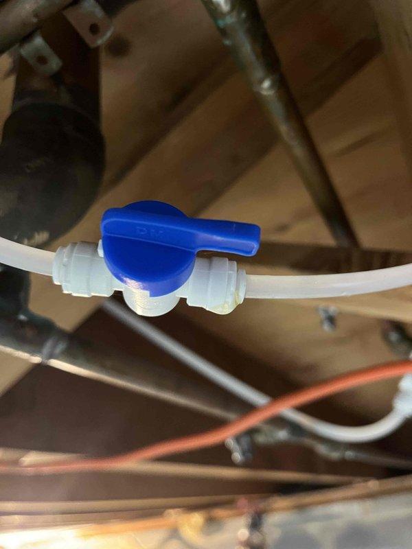 Responded to a water leak originating from the first floor bathroom. Upon inspection, accessed the area below through the basement/crawlspace and located the source of the leak in the plumbing supply lines. Installed a new shut-off valve with blue lever handle on the white PEX supply line to isolate the affected section and prevent future leaks. Secured all plumbing lines properly to the wooden floor joists and verified all connections were tight and leak-free before completing the repair.