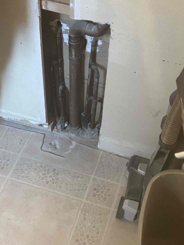 Performed follow-up service on outdoor spigot installation where wall access had been previously opened. Accessed plumbing through existing interior wall opening to complete connection work on exterior hose bib mounted on brick facade. Verified proper installation and operation of outdoor faucet fixture.