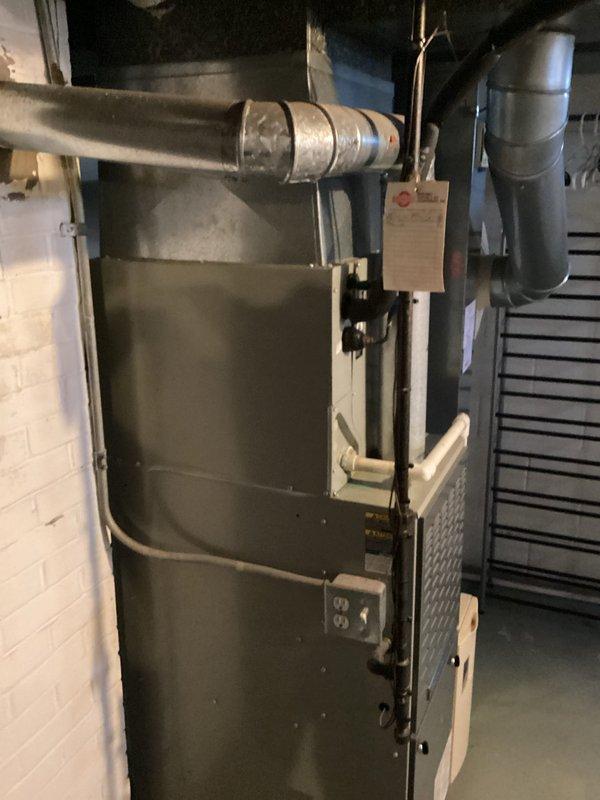 Conducted comprehensive assessment of existing HVAC system in residential basement mechanical room to provide replacement estimate for furnace and air conditioning equipment. Evaluated current American Standard furnace installation, associated ductwork configuration, and cooling system components. Documented existing equipment specifications, duct connections, electrical requirements, and spatial constraints for proper system replacement planning. Photographed current installation showing vertical furnace unit with metallic supply ductwork, humidifier integration, and electrical panel connections to ensure accurate equipment sizing and replacement specifications for both heating and cooling systems.