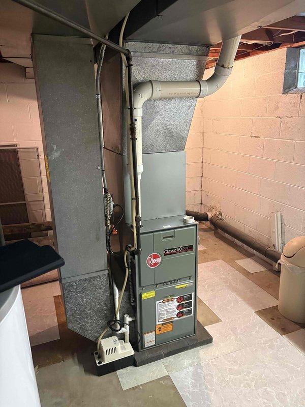 Conducted comprehensive HVAC system evaluation for replacement estimate on 20-year-old Rheem Climate Plus Series gas furnace and matching 20-year-old air conditioning system, both currently operational. Documented existing equipment configuration in basement mechanical room, including furnace installation with PVC venting system, refrigerant line routing, and electrical panel circuit assignments for HVAC equipment. Assessment confirmed both heating and cooling systems have reached end of expected service life and are candidates for replacement with modern high-efficiency equipment.