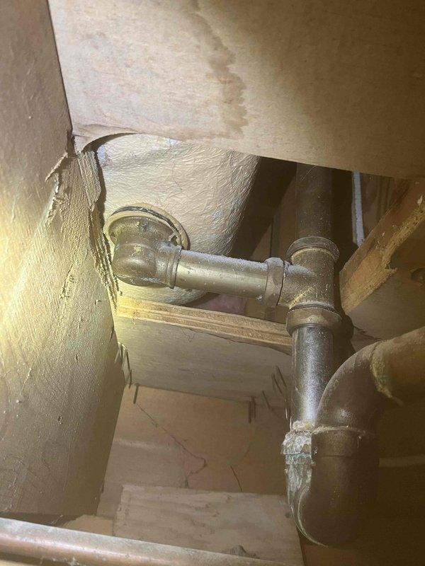 Completed inspection of sump pump system and associated plumbing components. During the inspection, examined interior plumbing fixtures including Kohler faucet assembly and drain mechanisms, removed and inspected curved plumbing component for wear and functionality. Accessed crawl space area to evaluate sump pump discharge piping, verified brass T-junction fittings and connections for proper installation and potential leaks. All components photographed and documented for service records.